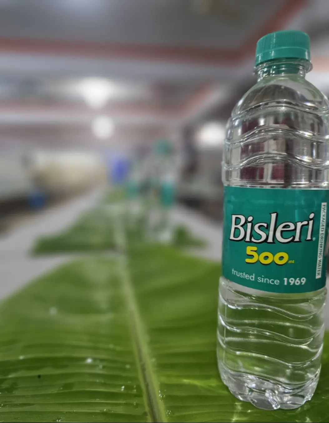 Bisleri water bottle placed on banana leaf dining setup