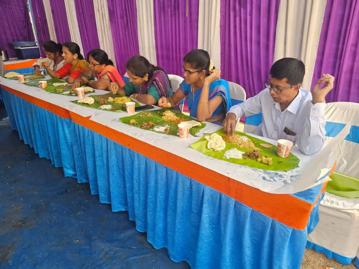 Guests enjoying traditional Andhra style banana leaf meal at a housewarming function in Bangalore