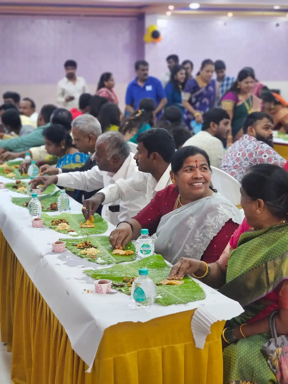Wedding guests dining on traditional banana leaf meal at Andhra style marriage function