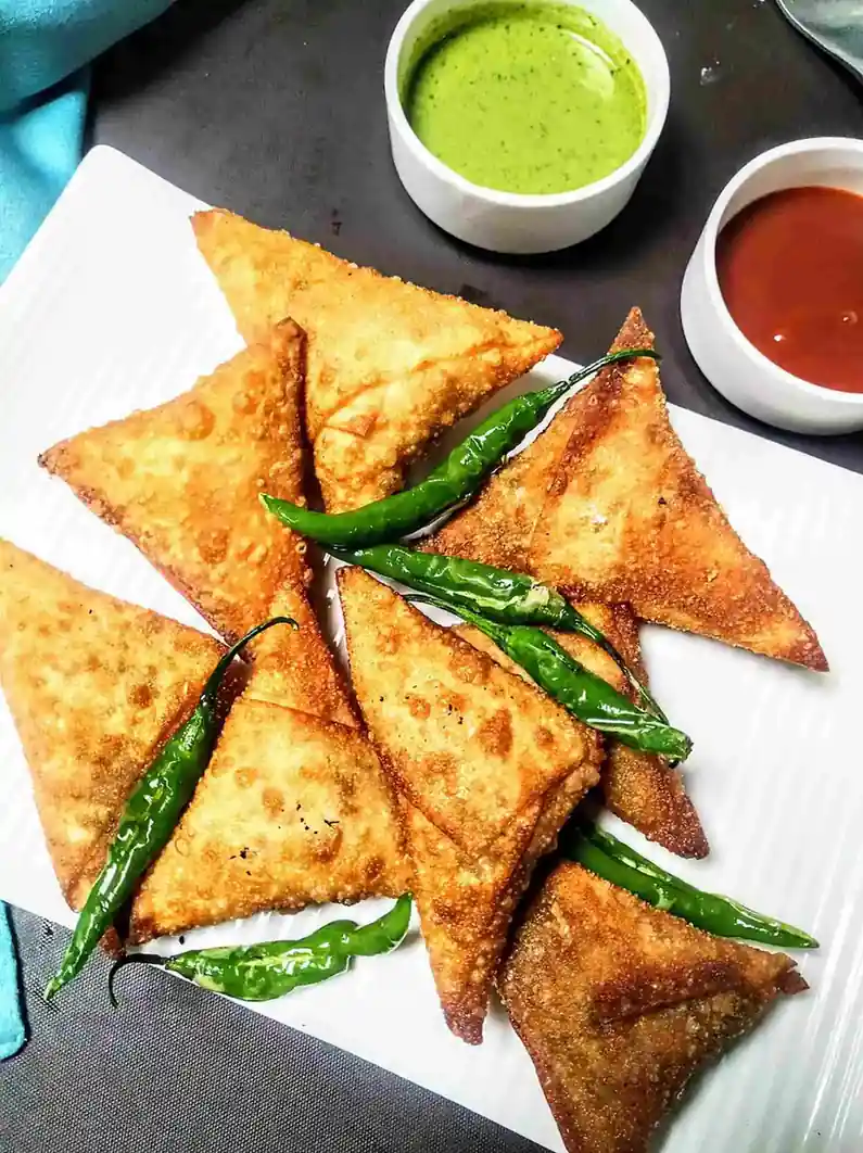 Golden fried mini samosas served with chutney