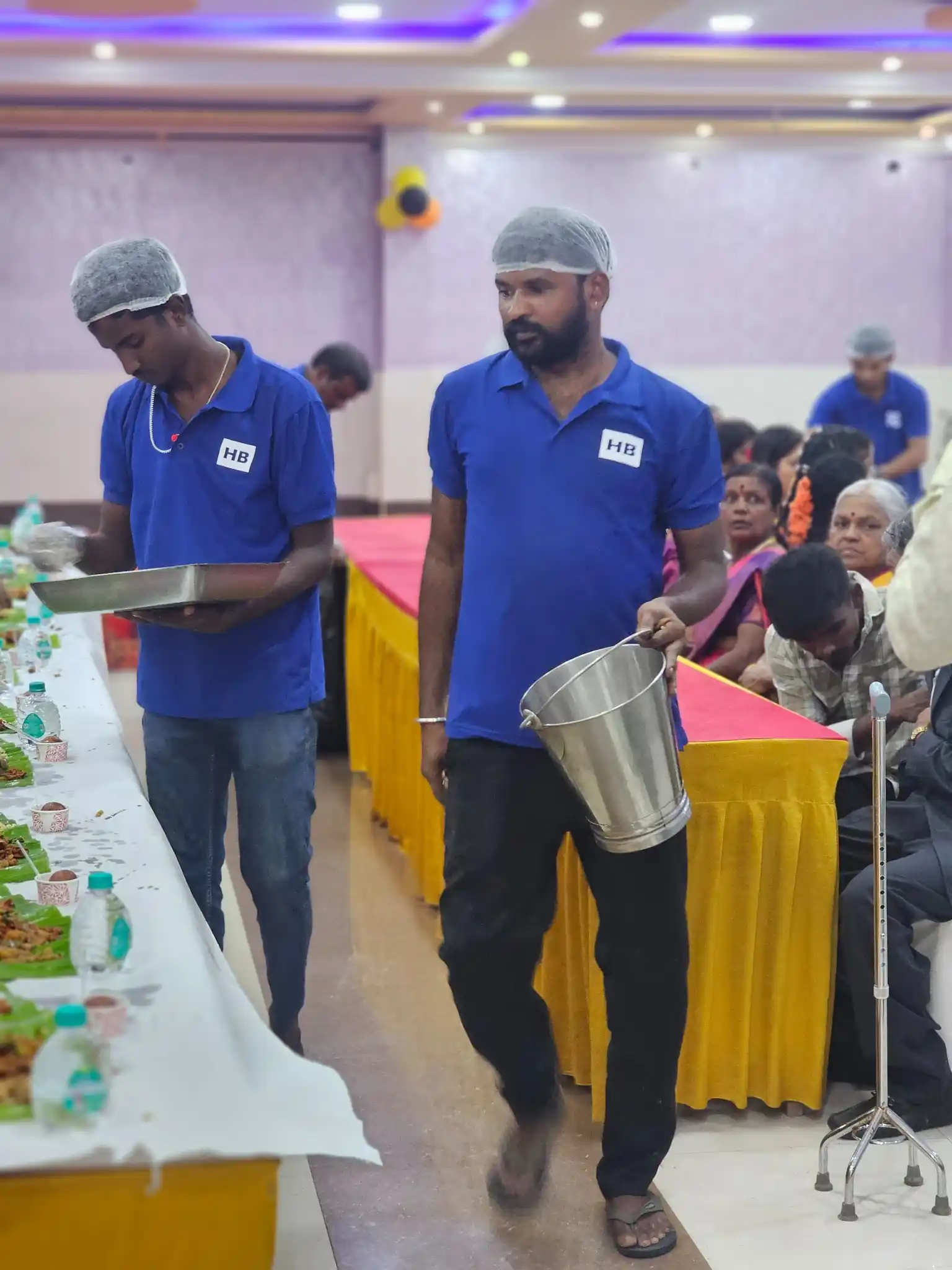 Guests dining on banana leaves at a South Indian style catering setup
