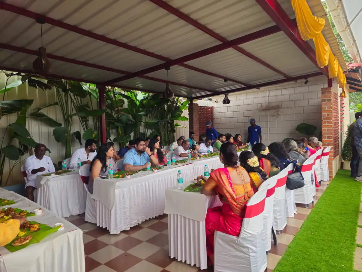 Large gathering enjoying festive banana leaf feast at an event