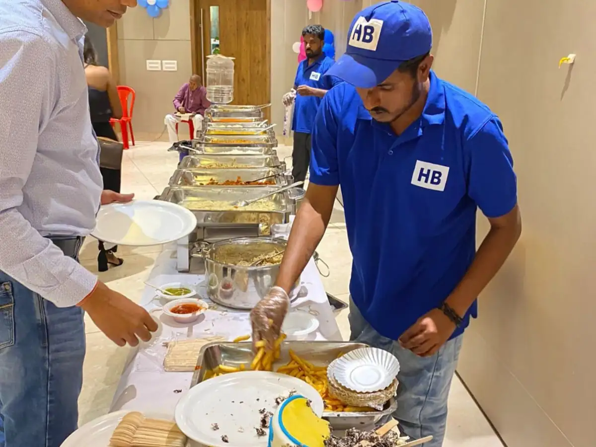 Birthday party catering service in Bangalore with professional staff serving food and cake at a family celebration