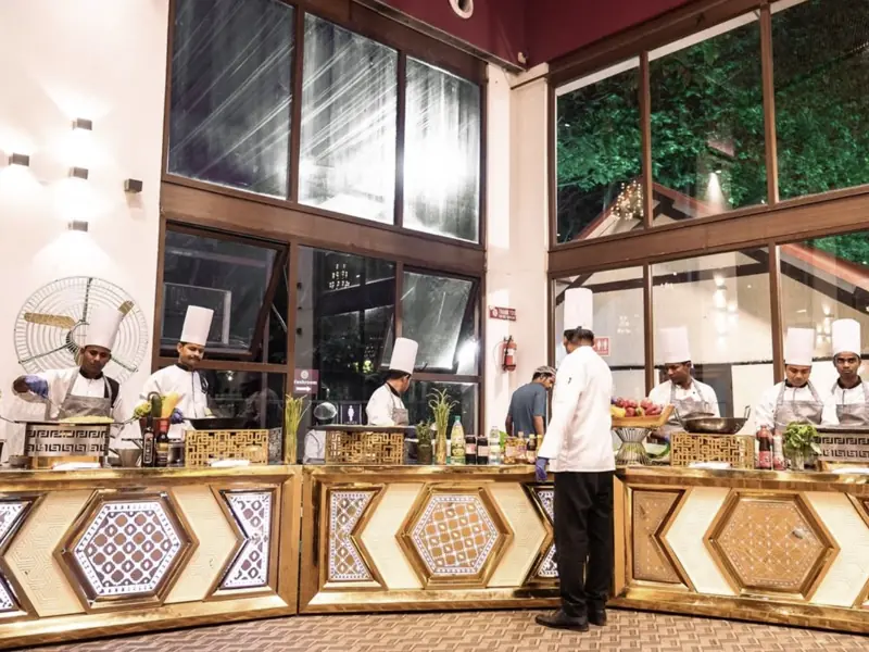 Elegant buffet food display with live counters and chefs serving dishes at an event
