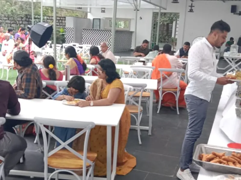 Community event food service with guests dining and buffet counters at a vegetarian catering event