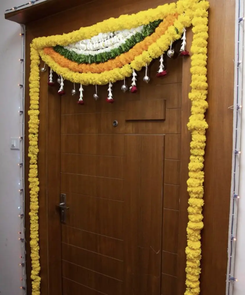 Traditional bedroom door floral arrangement with marigold flowers for gruhapravesha ceremony in Bangalore
