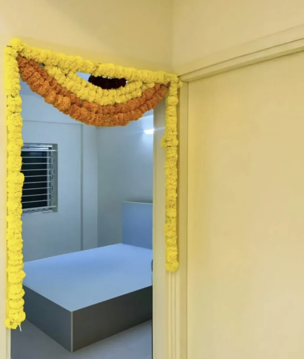 Bedroom door flower decoration with yellow and orange marigolds for gruhapravesha in Bangalore