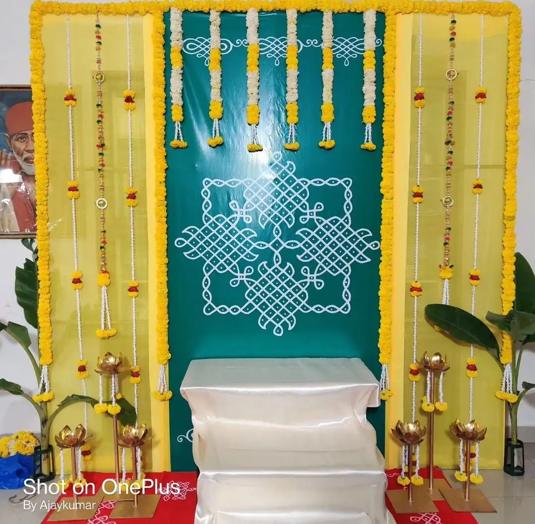 Simple gruhapravesha puja flower backdrop with yellow marigold vertical garlands