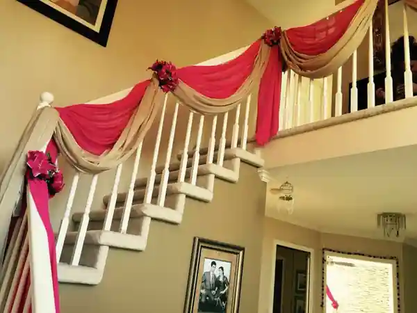 Housewarming balcony flower decoration with pink fabric drapes and floral arrangements in Bangalore