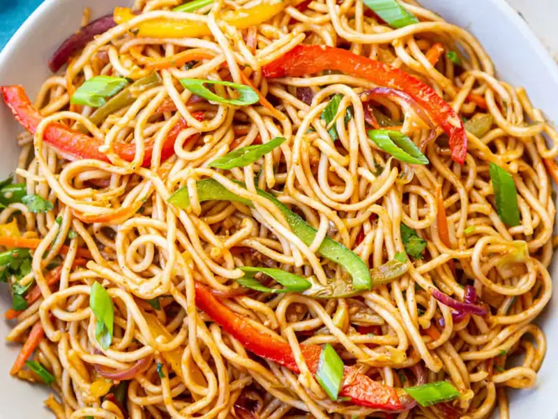 Vegetable noodles catering dish with stir-fried noodles, bell peppers and spring onions