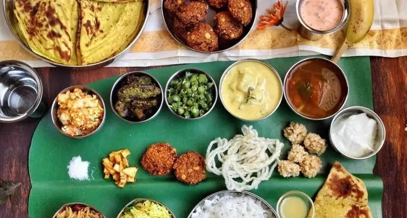 Traditional Tamil Nadu vegetarian catering meal served on banana leaf with rice, curries, sweets and accompaniments
