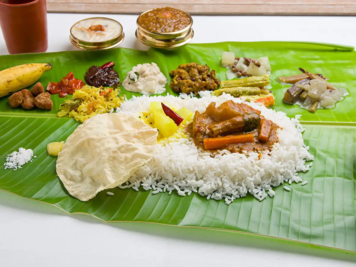 Traditional vegetarian wedding lunch served on banana leaf with rice, sambar, rasam, curries, sweets and papad