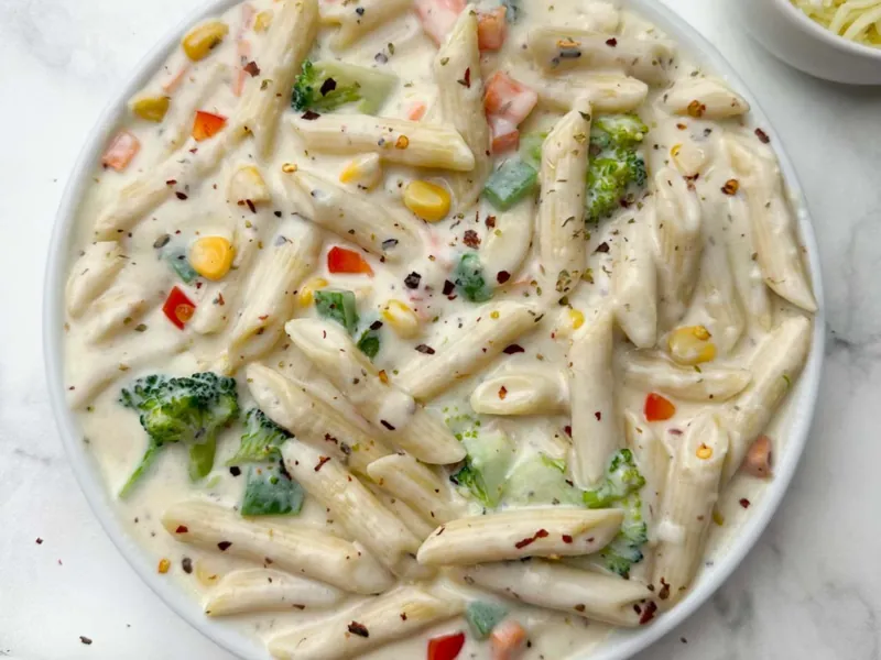 Creamy white sauce pasta with penne, broccoli, corn and vegetables served for catering