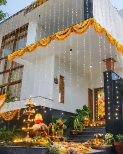Traditional house warming ceremony decoration in Bangalore with floral garlands, lights and pooja setup
