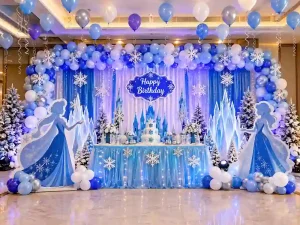 Frozen theme birthday decoration in Bangalore with blue balloon arch, snowflakes and winter wonderland backdrop