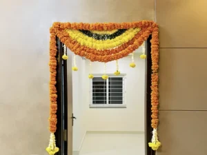 Housewarming bedroom door decorated with yellow and orange flower garlands in Bangalore