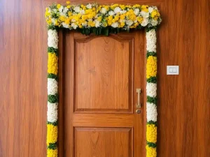 Traditional housewarming door flower decoration with yellow and white flowers in Bangalore