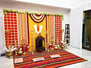 Housewarming pooja backdrop decorated with traditional flowers and pooja setup in Bangalore