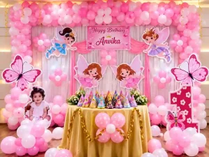 Pink fairy themed birthday decoration with balloon arch and backdrop in Bangalore
