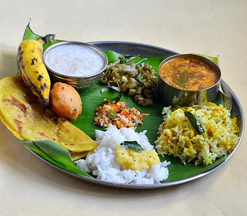 Caterer serving Andhra full meals on plate with banana leaf base