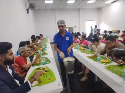 Family and guests enjoying festive banana leaf meal at a family function