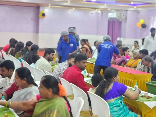 Guests seated in hall enjoying traditional Andhra lunch on banana leaves