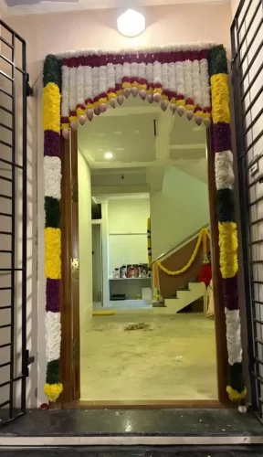 Colorful flower decoration arranged for apartment flat housewarming ceremony in Bangalore.
