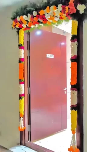 Elegant gruhapravesham entrance flower decoration with fresh flowers in Bangalore.