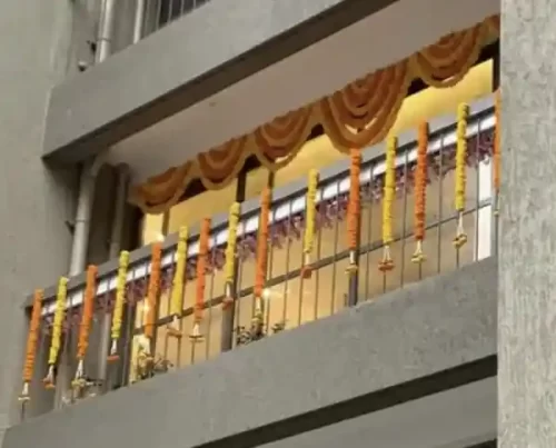 Griha pravesh balcony decorated with marigold garlands and fabric draping