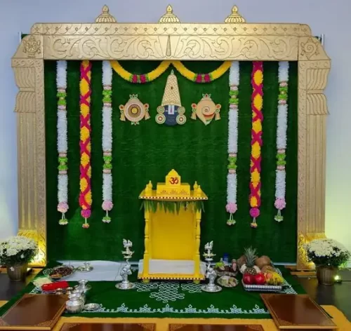 Griha pravesh puja flower decoration with marigold garlands and kolam backdrop