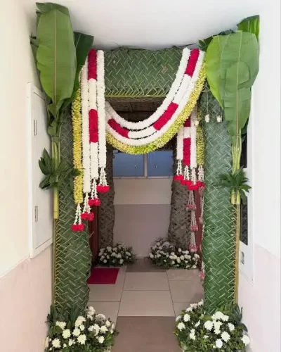 Traditional chappara flower decoration with banana leaves for gruhapravesha apartment entrance in Bangalore.