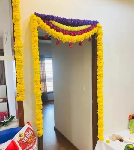 Fresh marigold flower setup around bedroom door during gruhapravesha ceremony in Bangalore