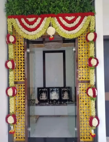 Gruhapravesha pooja room decorated with elegant flower arrangements