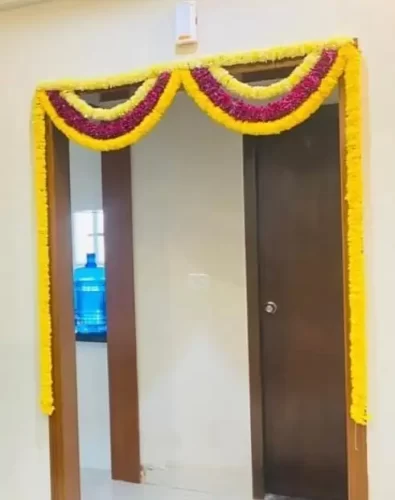 Traditional marigold flower decoration for bedroom door in gruhapravesha ceremony Bangalore.