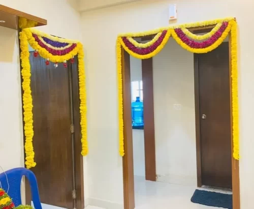 Bedroom door decor with colorful flower garlands for gruhapravesham ceremony in Bangalore