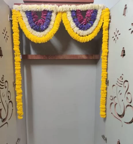 Gruhapravesham pooja room decorated with fresh flowers and banana leaves