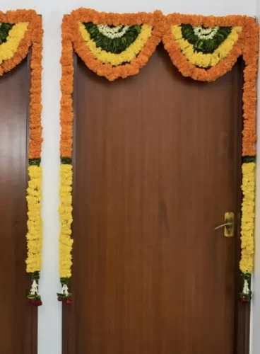 Simple bedroom door flower decor with marigolds for gruhapravesham in Bangalore