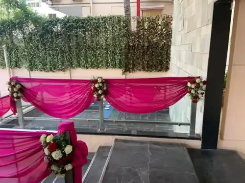 House warming balcony decorated with fabric swags and flower bouquets in Bangalore