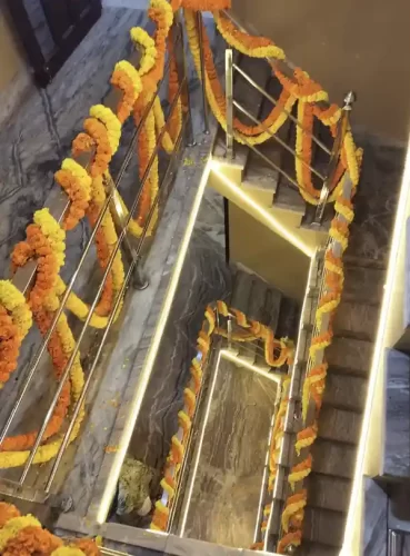 Staircase railing decorated with marigold garlands for house warming