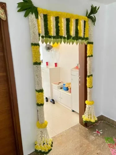Grand housewarming entrance decorated with premium fresh flowers and elegant floral arrangement in Bangalore