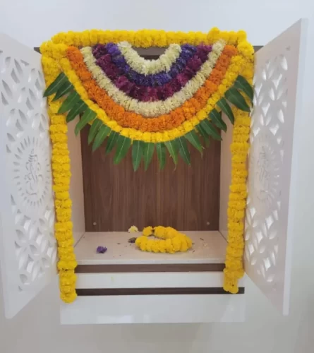 House warming puja room decorated with fresh flowers and traditional garlands in Bangalore