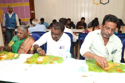 Caterers serving food on banana leaves at a traditional Andhra style meal